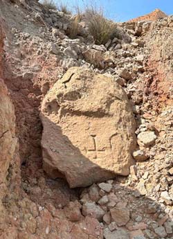 La roche gravée d'une croix.